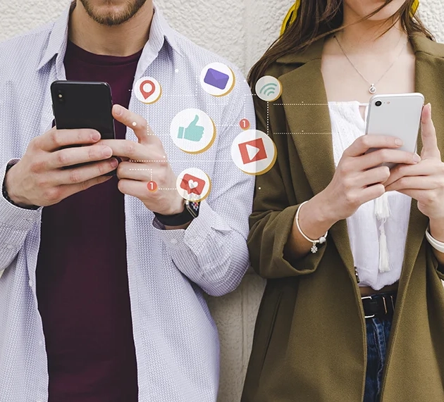 Dos personas compartiendo contenido en redes sociales con sus móviles
