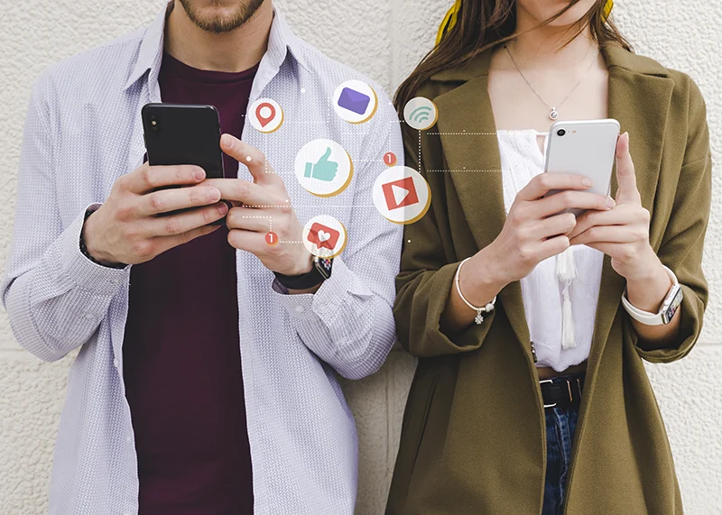 Dos personas compartiendo contenido en redes sociales con sus móviles