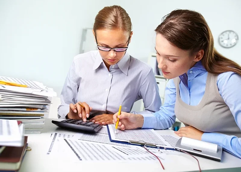 Mujeres con tablas y calculadora
